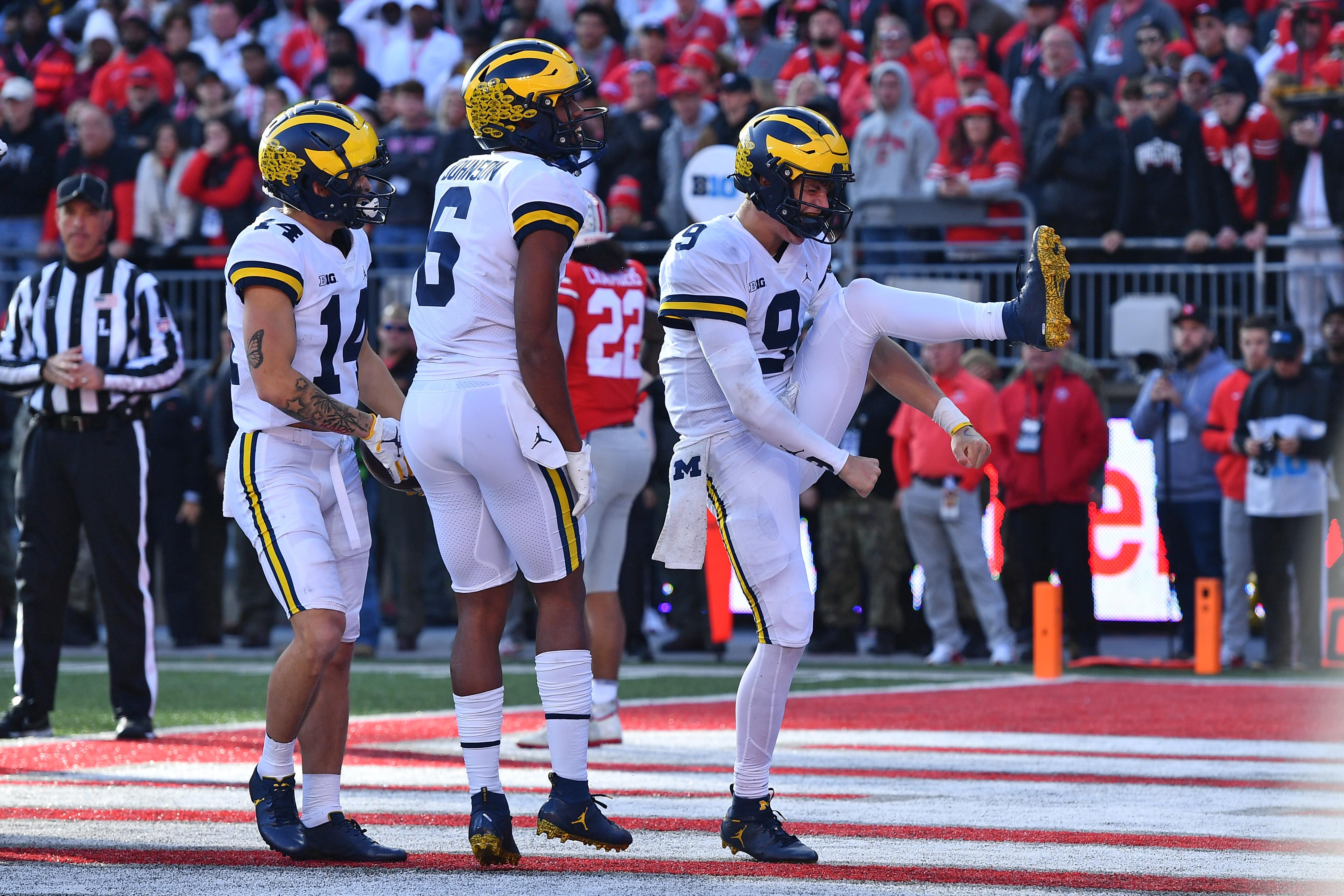 Three Michigan players in the end zone celebrate 