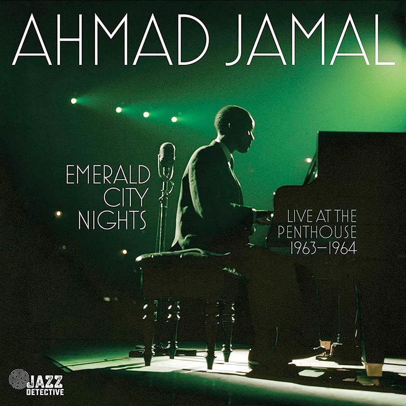 The artist is pictured at the piano lit from behind with green light on the cover of Emerald City Nights. 