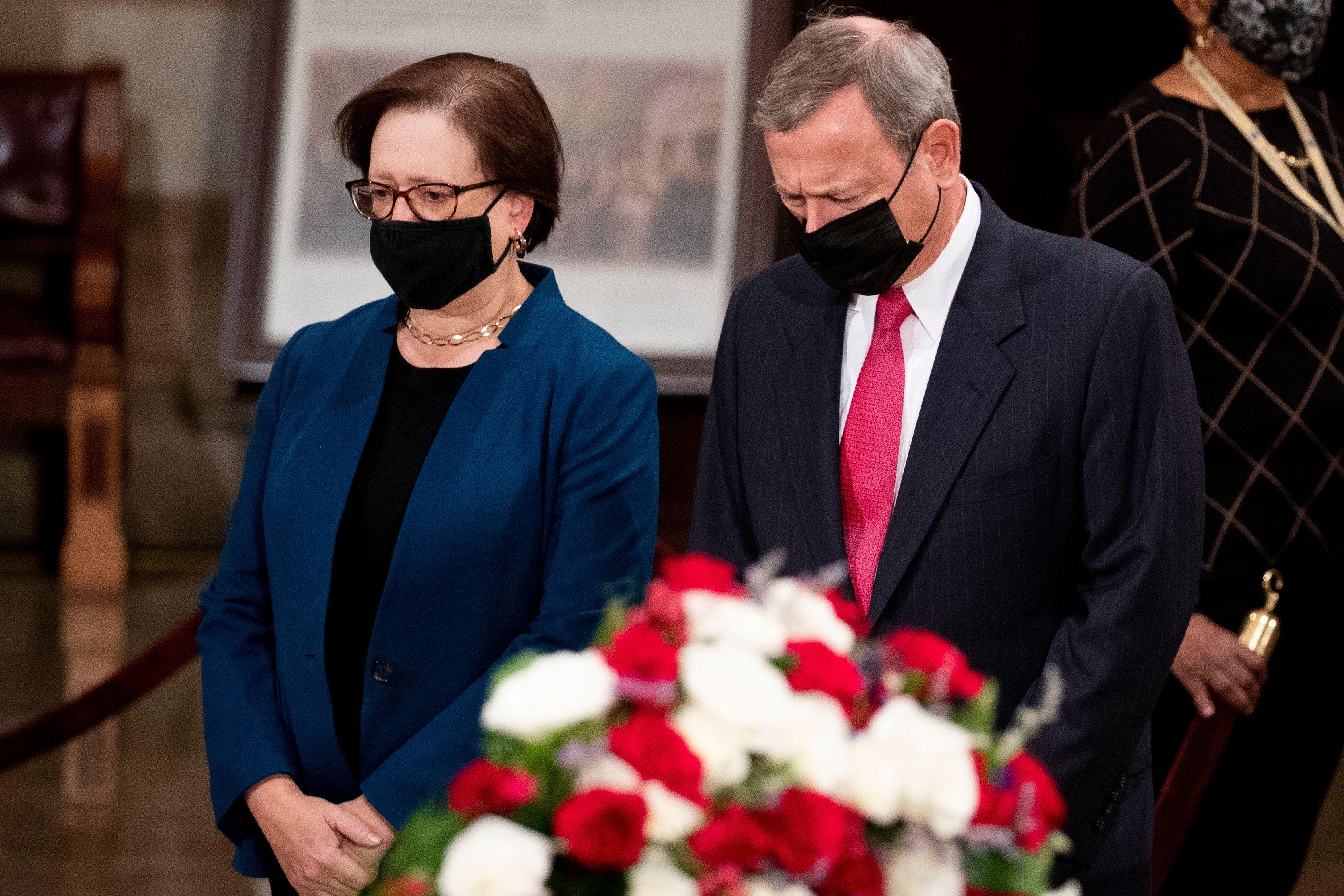 Kagan and Roberts stand in the Capitol rotunda looking mournful in black masks