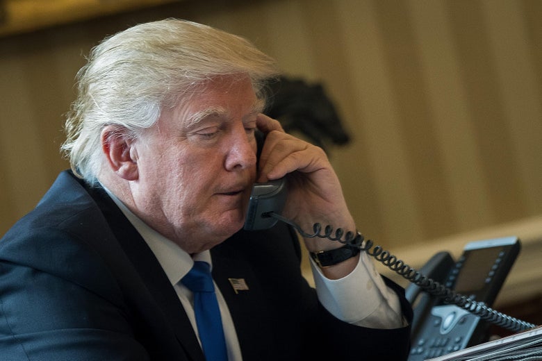 President Donald Trump speaks on the phone with Russian President Vladimir Putin in the Oval Office of the White House, January 28, 2017 in Washington, DC. 