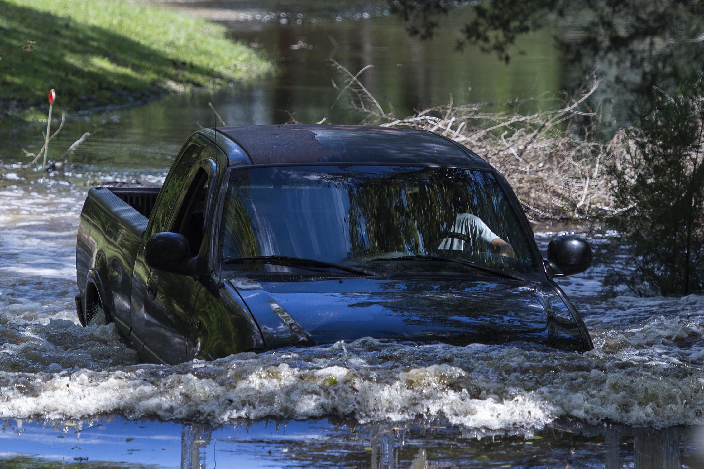A truck drives through deep flood water in Rhems, North Carolina on September 18, 2018. - Rain-gorged rivers threatened further flooding on the storm-battered US East Coast Monday as the death toll from Hurricane Florence, now a tropical depression, jumped to 31. (Photo by Andrew CABALLERO-REYNOLDS / AFP)        (Photo credit should read ANDREW CABALLERO-REYNOLDS/AFP/Getty Images)