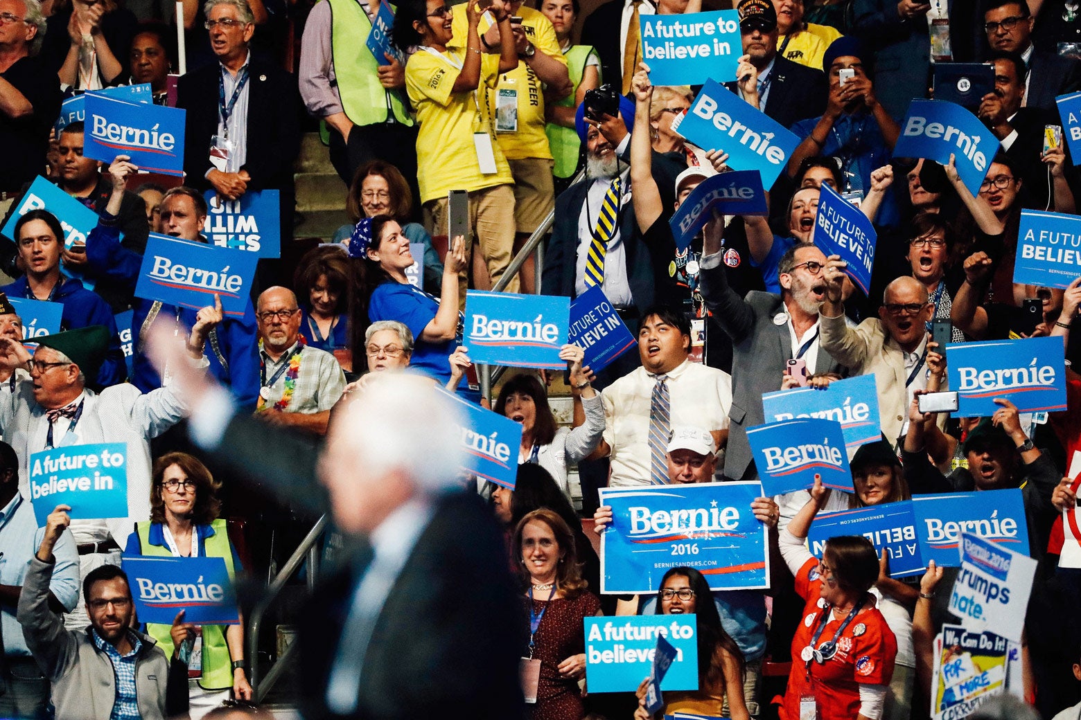Supporters of Sen. Bernie Sanders stand and cheer as he delivers remarks.