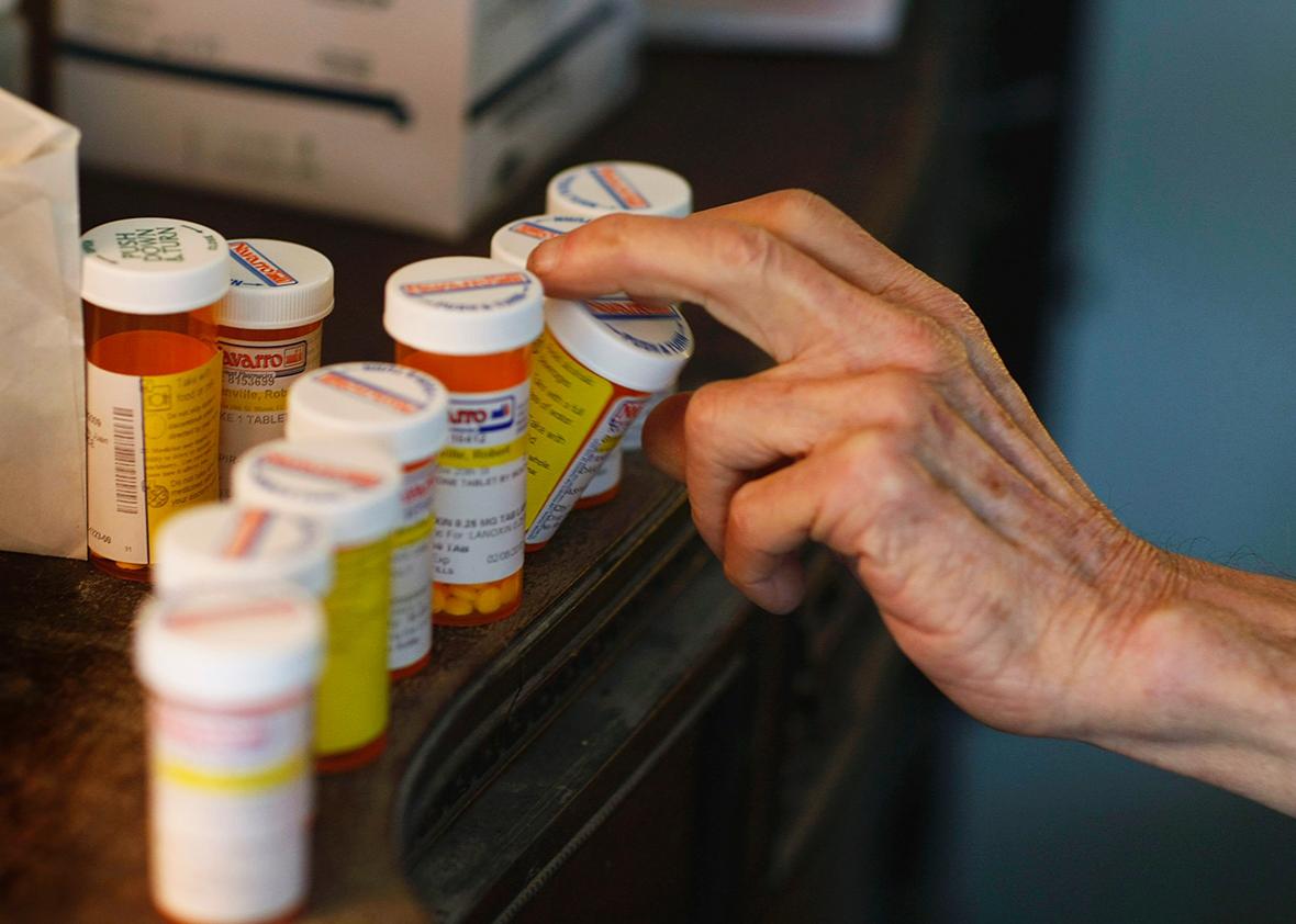 A man reaches for a medicine bottle as he takes his prescription pills on February 25, 2009 in Miami, Florida. 