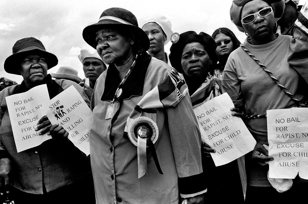 Members of the ANC Women's League hold out flyers that they were distributing at the funeral of 3yr old S'bongile Mokoena who was raped and murdered on November 8, 2003. Soweto, December 2003.