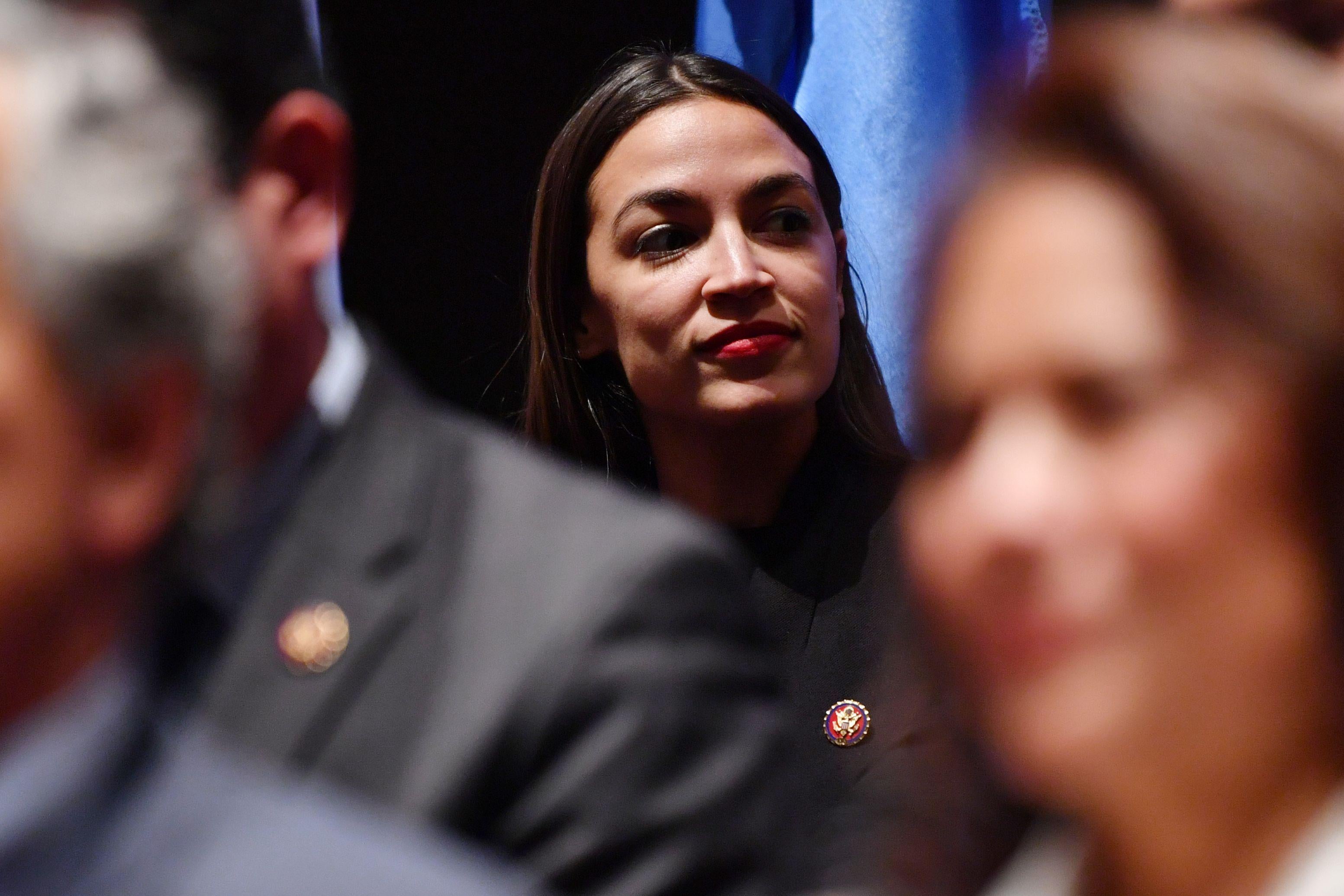 Alexandria Ocasio-Cortez with other members of Congress visible in the foreground.