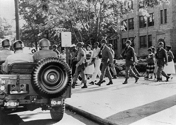 Nine black children are escorted by US paratroopers in full battle dress on September 25, 1957 in Little Rock, Arkansas from Central High School.