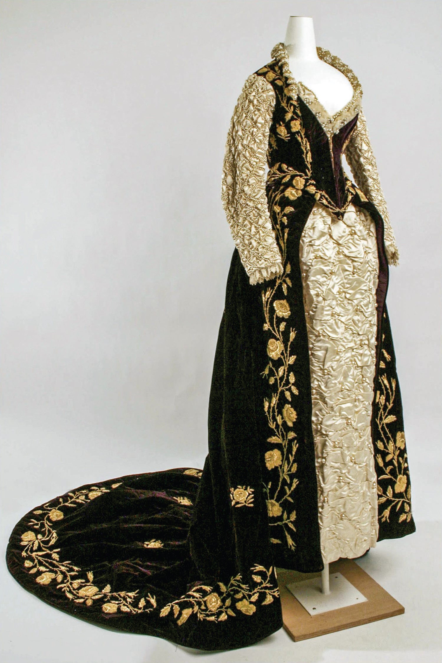 An elaborate gown featuring gold embroidery, with an open front and a train.