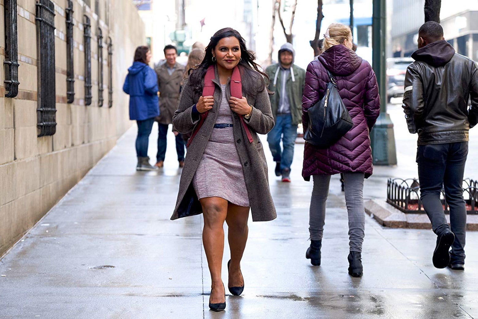 Kaling as Molly Patel, walking down a city street wearing a backpack and smiling excitedly.