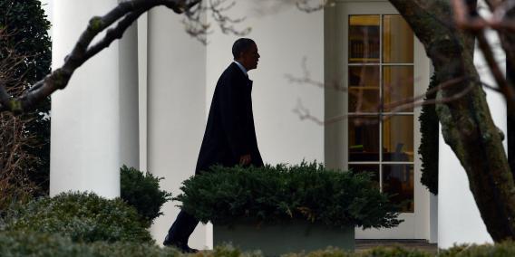 President Barack Obama walks to the Oval Office upon returning at the White House.