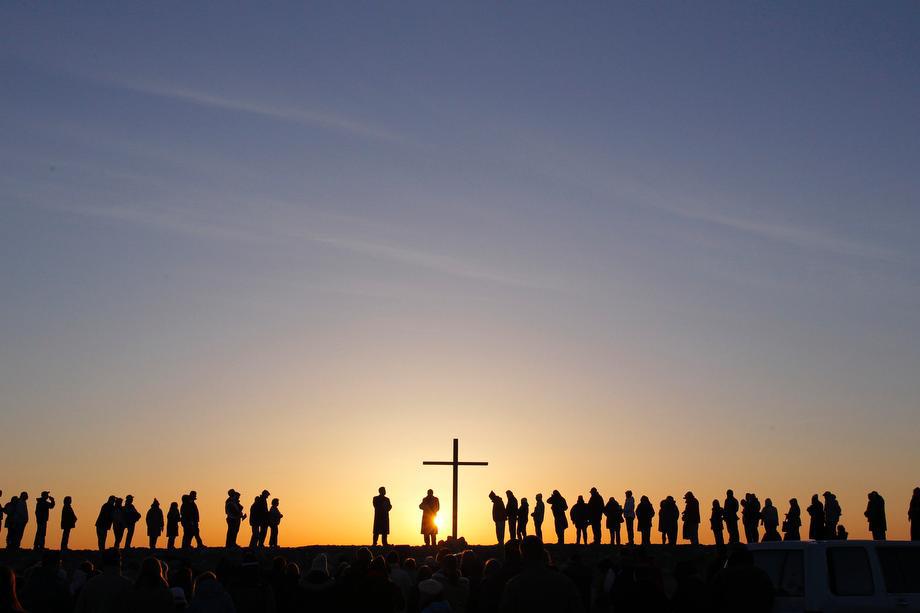 People are silhouetted as the sun rises during an Easter sunrise service in Scituate, Massachusetts on March 31, 2013.