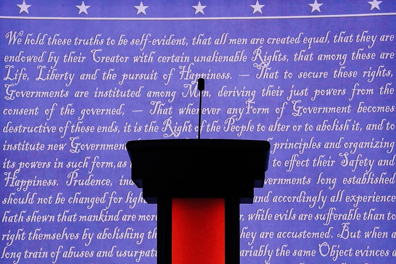 Empty podium in front of a blue screen with the Constitution written in white. 