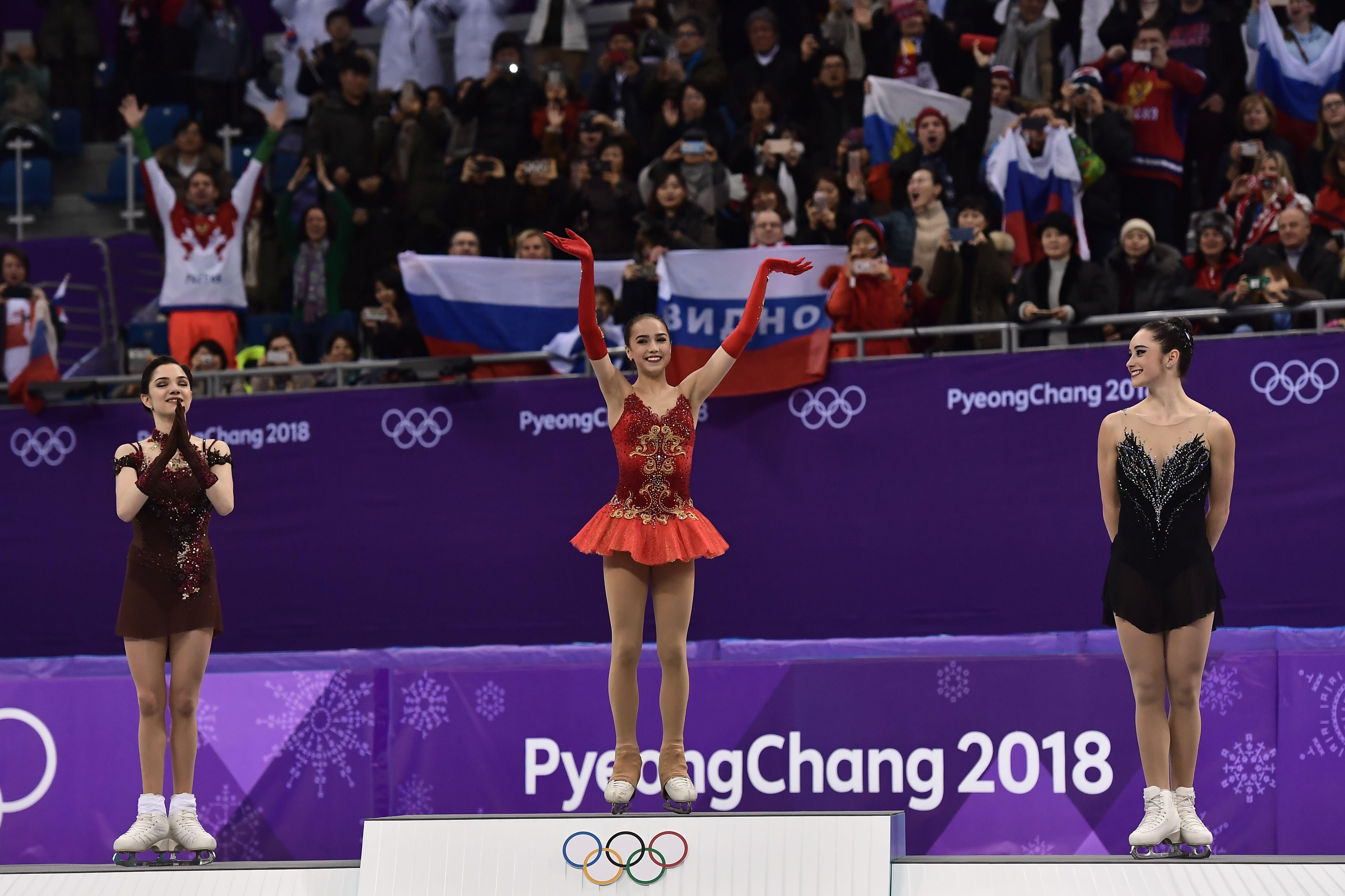 (L-R) Silver medallist Russia's Evgenia Medvedeva, gold medallist Russia's Alina Zagitova and bronze medallist Canada's Kaetlyn Osmond celebrate on the podium during the venue ceremony after the women's single skating free skating of the figure skating event during the Pyeongchang 2018 Winter Olympic Games at the Gangneung Ice Arena in Gangneung on February 23, 2018. / AFP PHOTO / ARIS MESSINIS        (Photo credit should read ARIS MESSINIS/AFP/Getty Images)