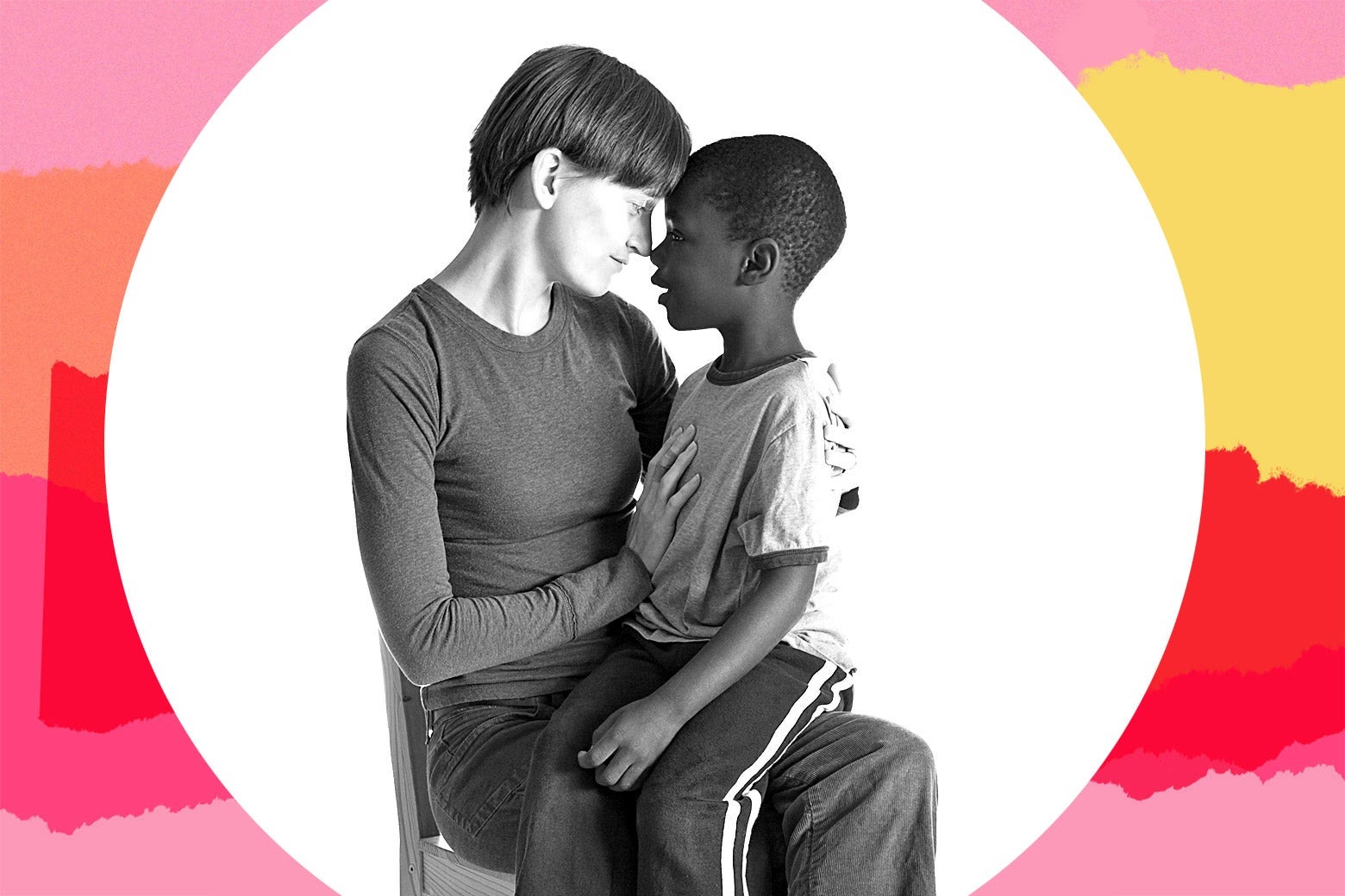 A white woman sitting down, holding a Black child in her lap, their foreheads touching.
