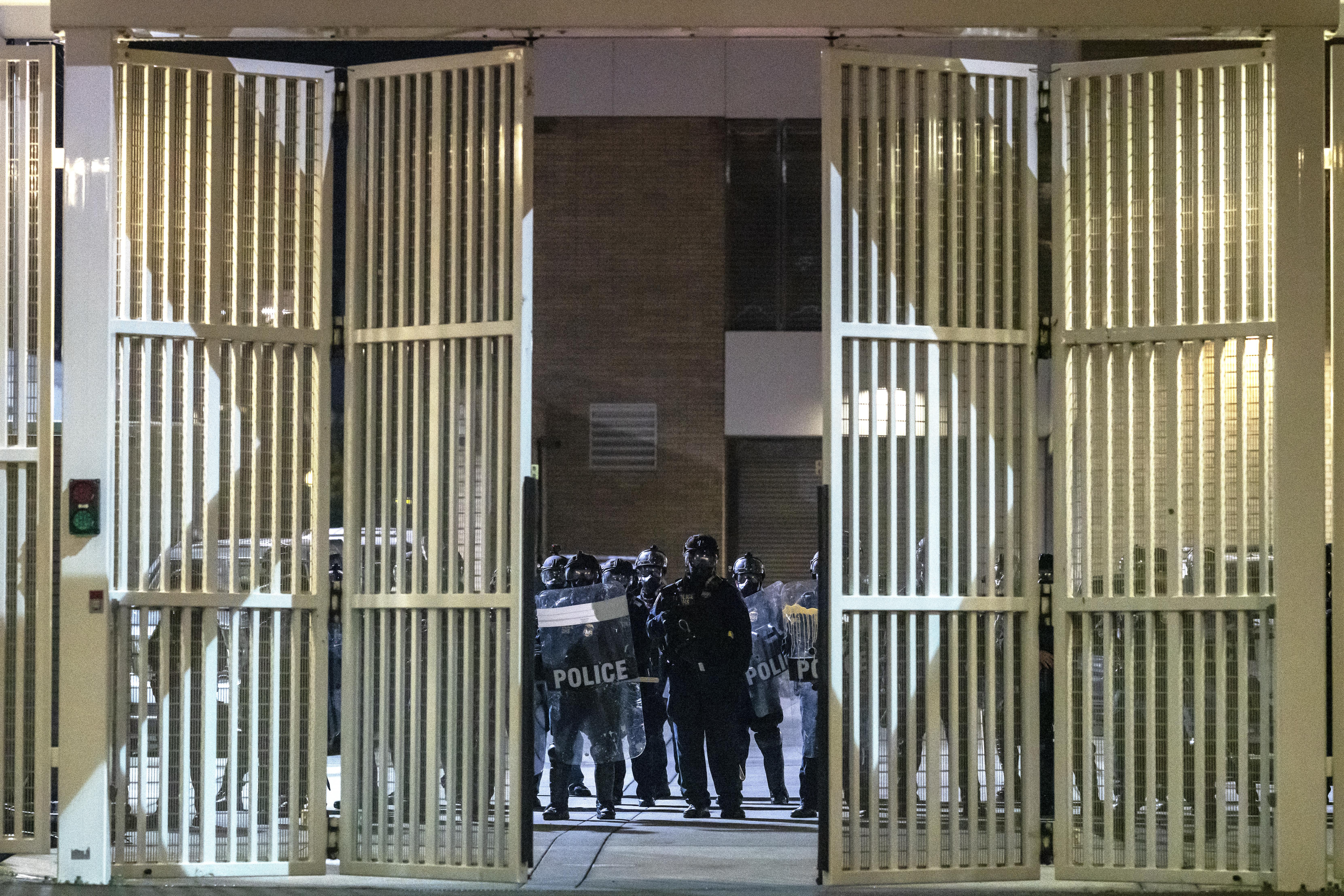 Federal officers guard the front gate of the ICE detention center during a protest in Portland, Oregon. 