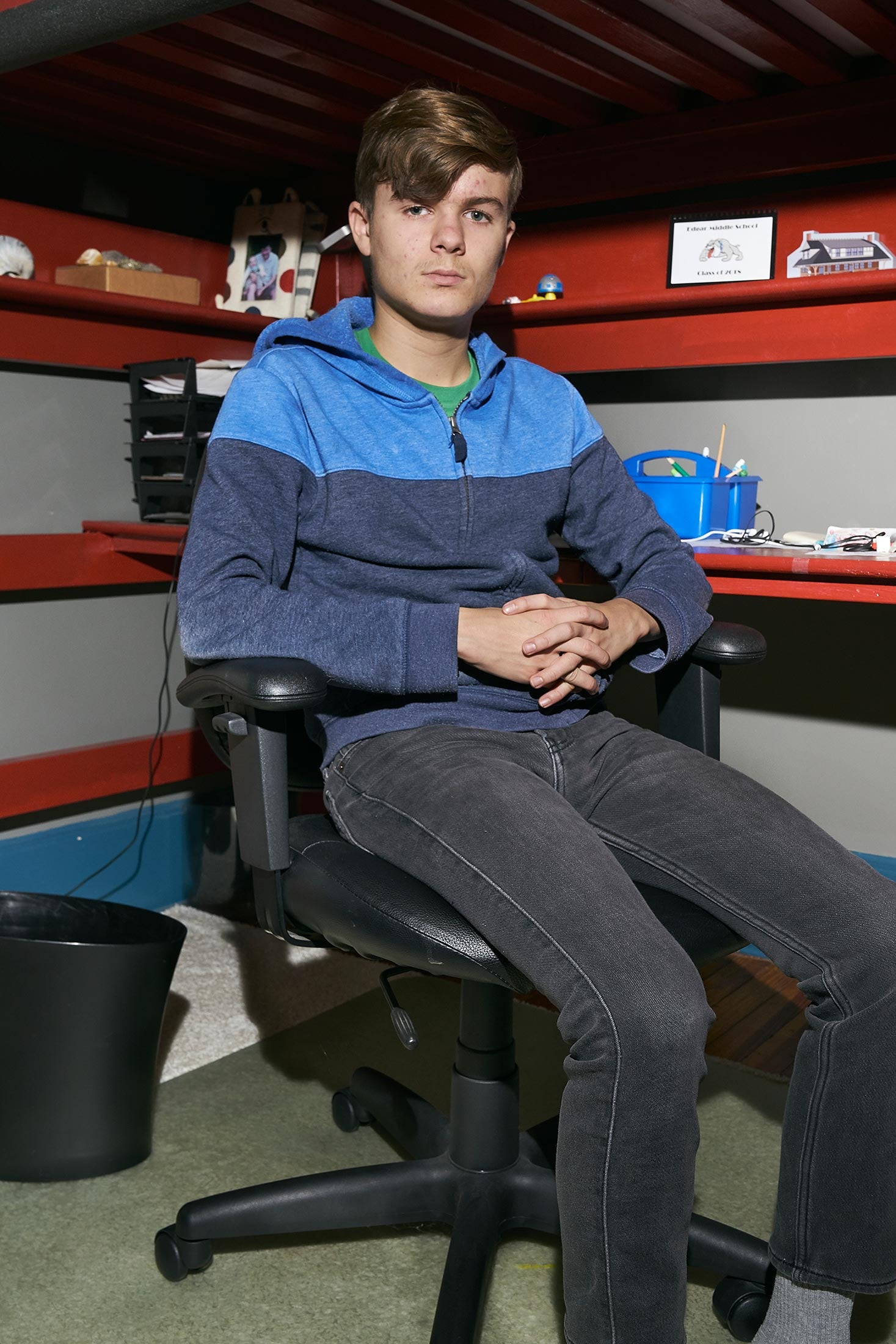 Colin, sitting on a swivel chair in his bedroom, 10th grade.