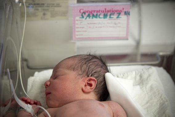 A newborn baby rests in a nursery.