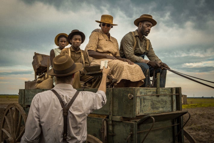 Still from Mudbound showing Jason Mitchell as Ronsel Jackson and Mary J. Blige as Florence Jackson being flagged down while driving a cart. 