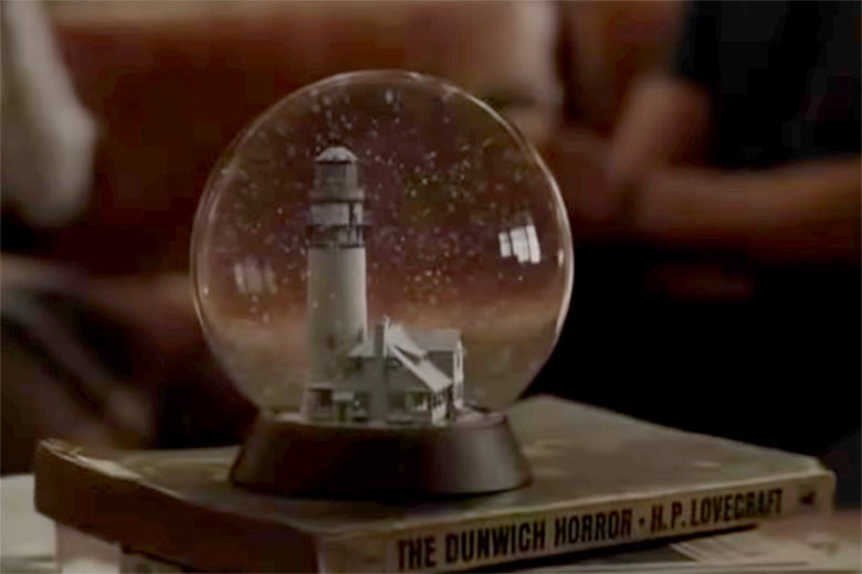 A snow globe on top of H.P. Lovecraft's The Dunwich Horror.