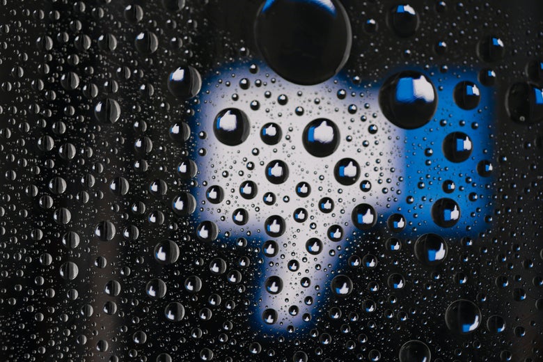 A large Facebook thumbs down behind water droplets containing Facebook thumbs ups.