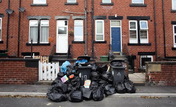 Overflowing refuse bins litter the streets.