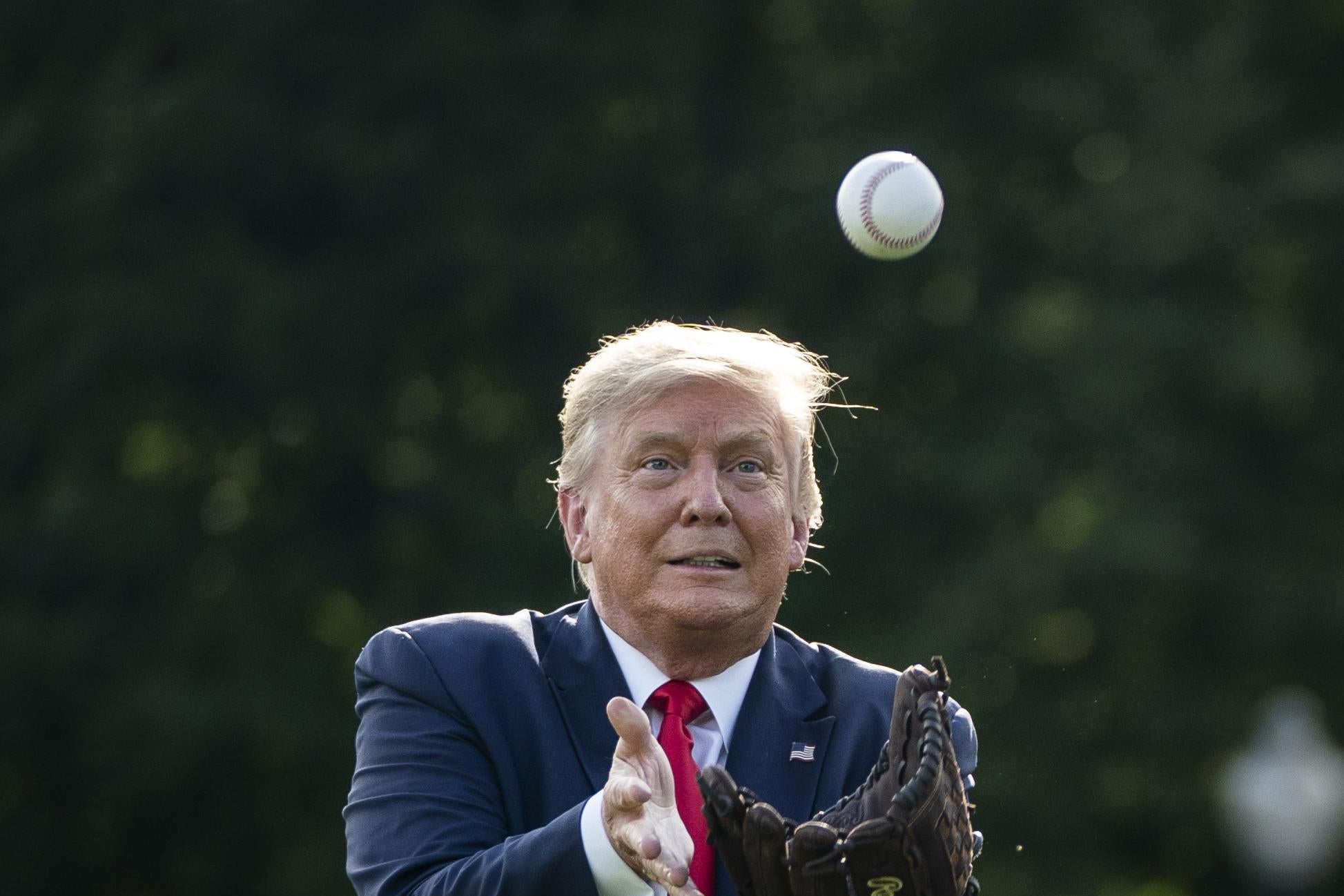 Then-President Donald Trump catches a baseball thrown by former New York Yankees Hall of Fame pitcher Mariano Rivera on the South Lawn of the White House on July 23, 2020 in Washington, D.C.