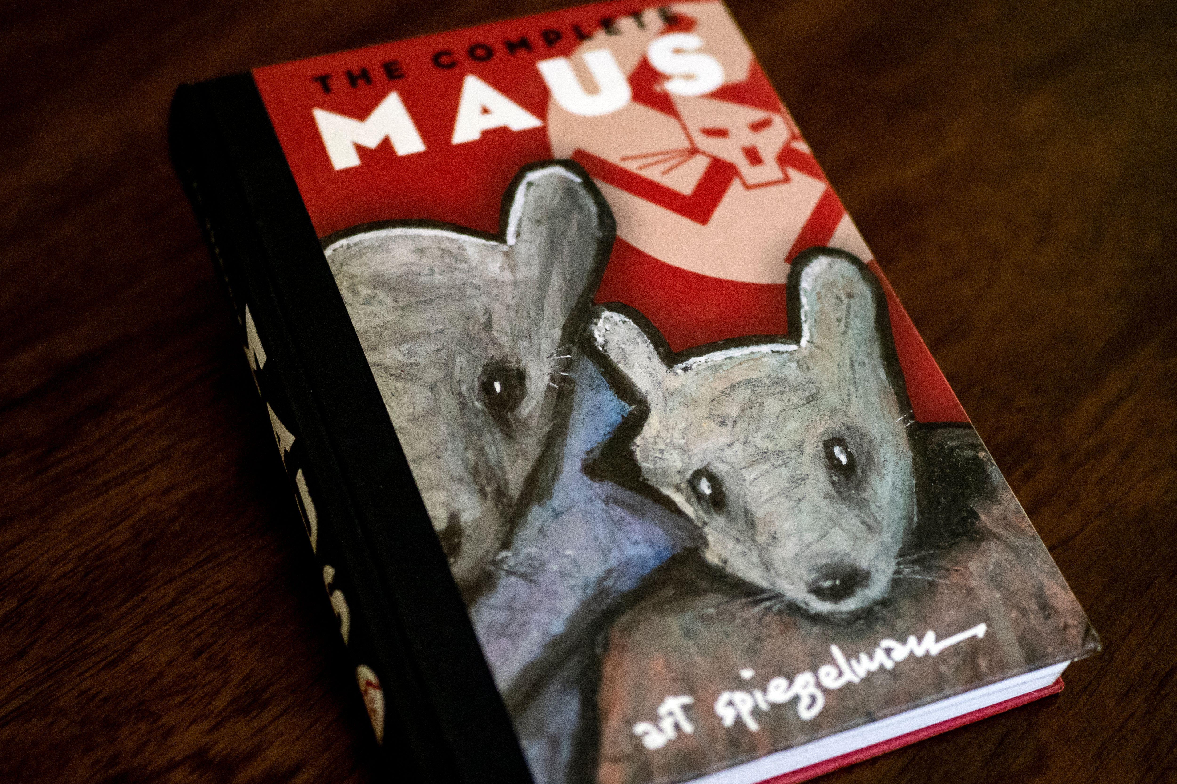 Hardcover copy of The Complete Maus graphic novel on a wooden table