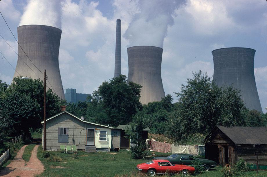 Water cooling towers of the John Amos Power Plant loom over Poca, WV, home that is on the other side of the Kanawha River. Two of the towers emit great clouds of steam.” Harry Schaefer, Poca, West Virginia, August 1973