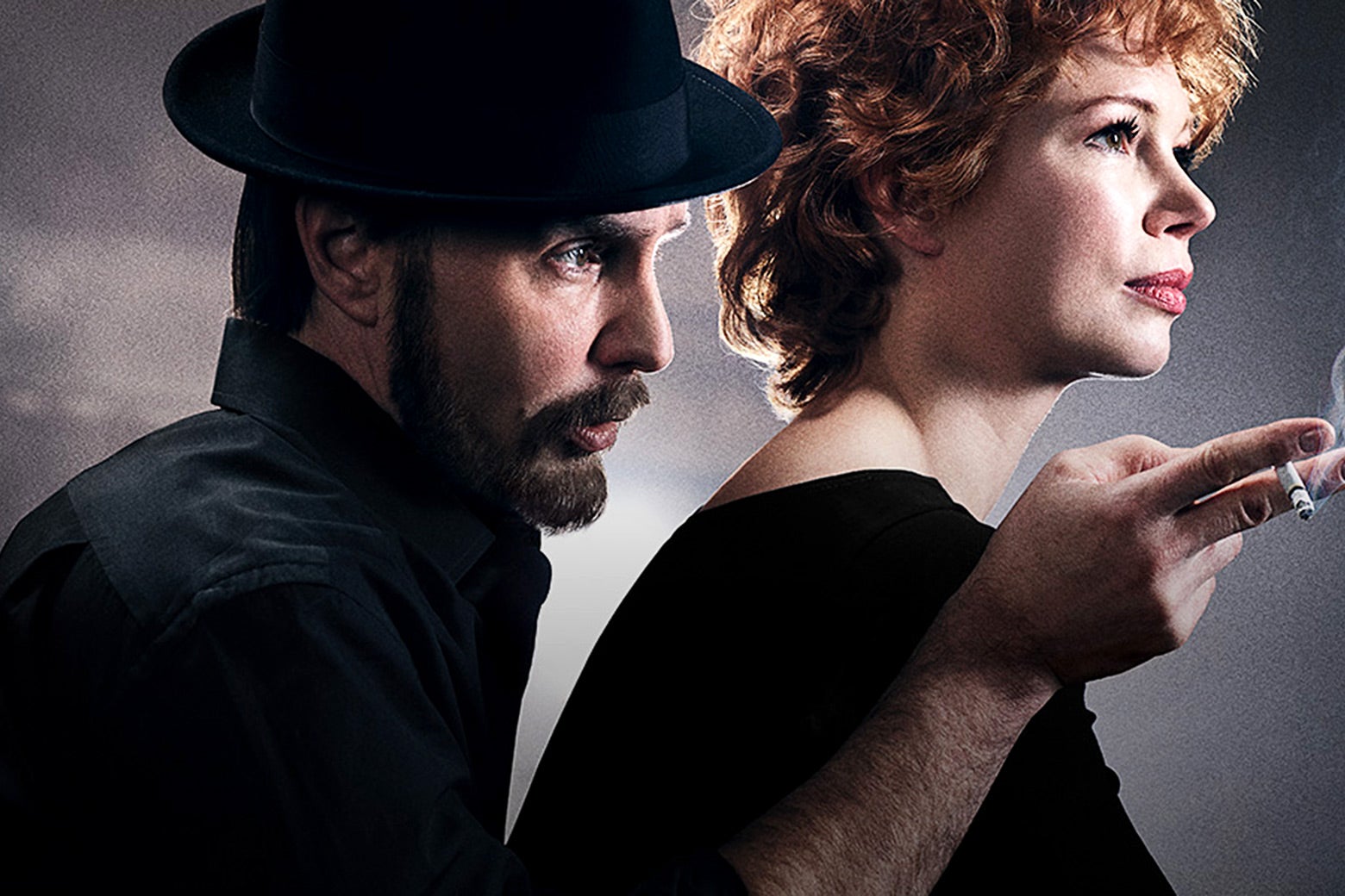 A hat-clad Sam Rockwell, as Bob Fosse, leans over Michelle Williams, as Gwen Verdon, gesturing off-camera over her shoulder with a hand holding a lit cigarette.