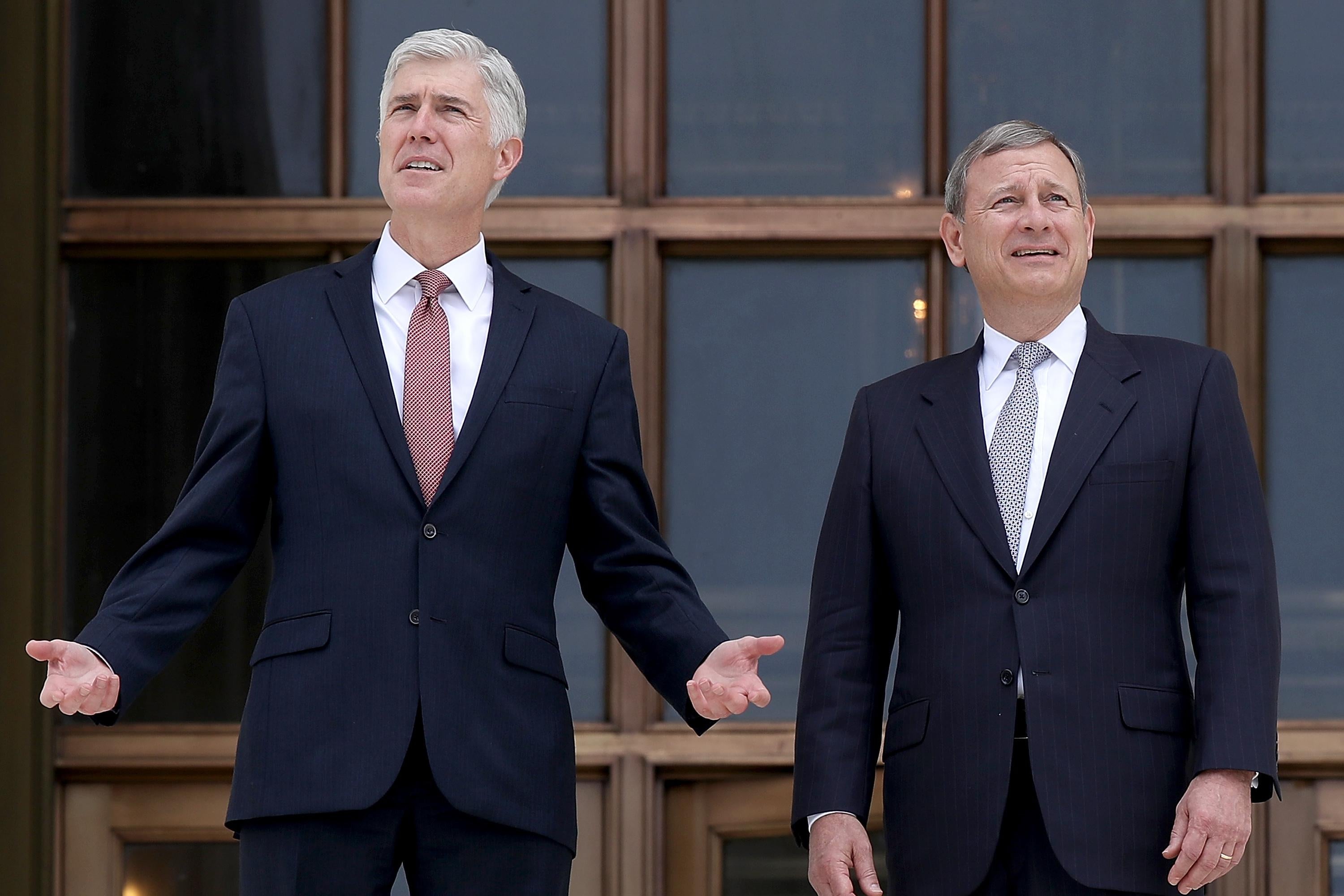 Neil Gorsuch and John Roberts talking to each other in front of the Supreme Court.