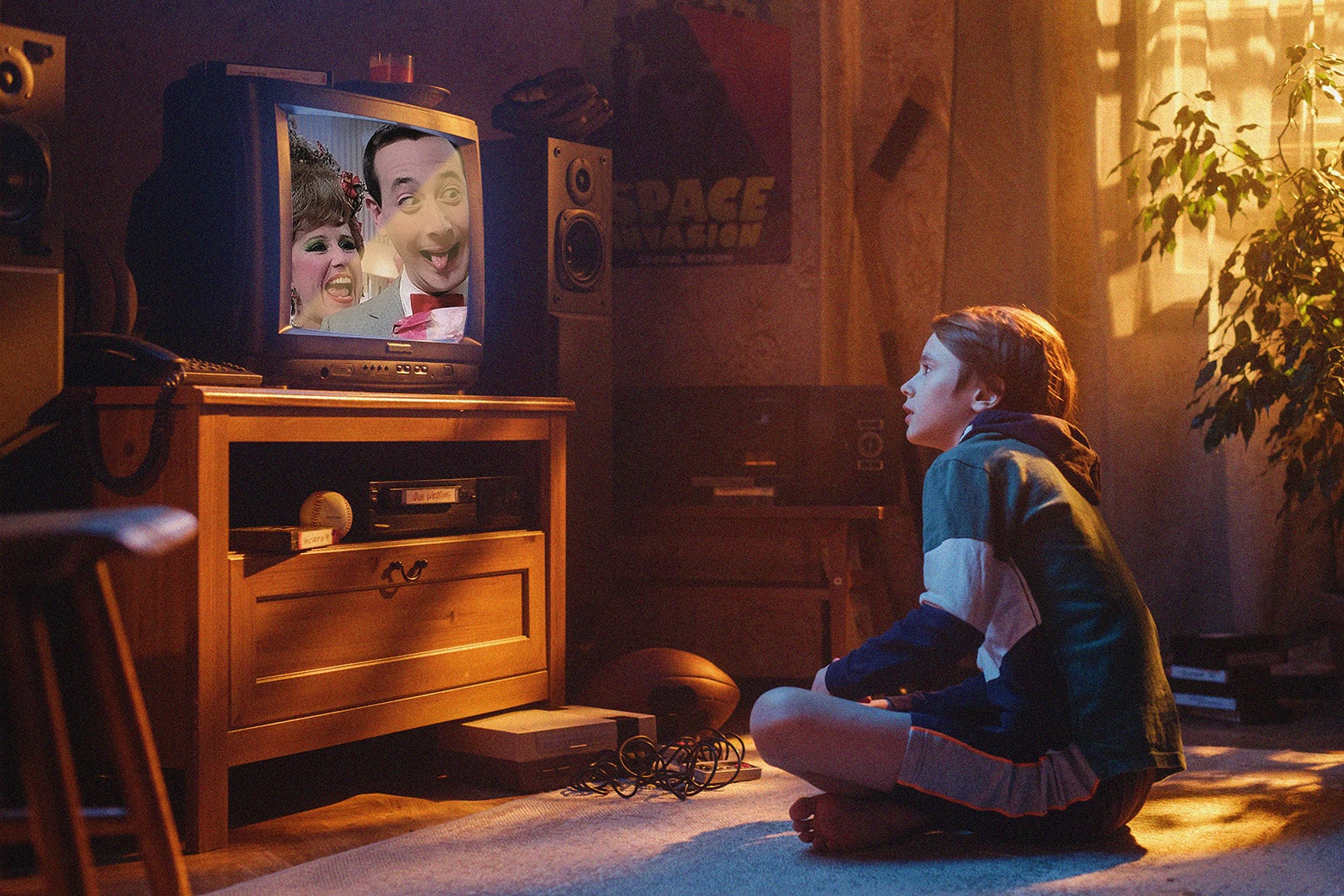 A kid sitting in a living room and watching an old episode of Pee-wee's Playhouse.